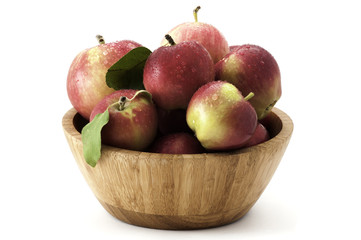 Apples with water droplets in wooden bowl isolated on white backgroun
