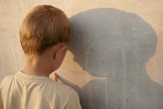 sad little boy near the wall