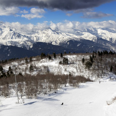 Skiers on ski slope at sun winter day