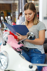 Young female is choosing modern motobikes