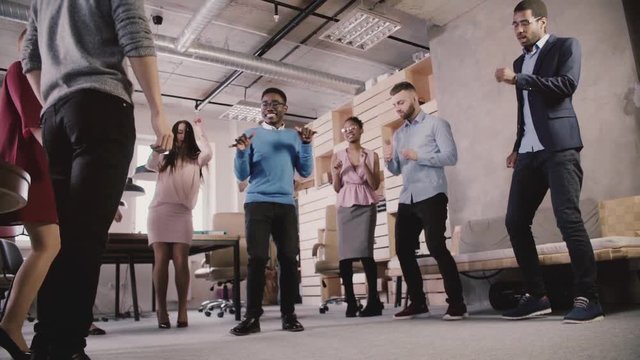 Multiethnic Business People Celebrate Business Sucess At Teambuilding Casual Dance Party In Modern Office Slow Motion.