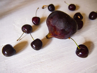 ripe figs and cherries on a wooden surface