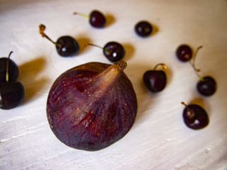 ripe figs and cherries on a wooden surface