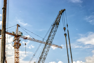 Towers of the cranes. Construction site with cranes against the blue sky.
