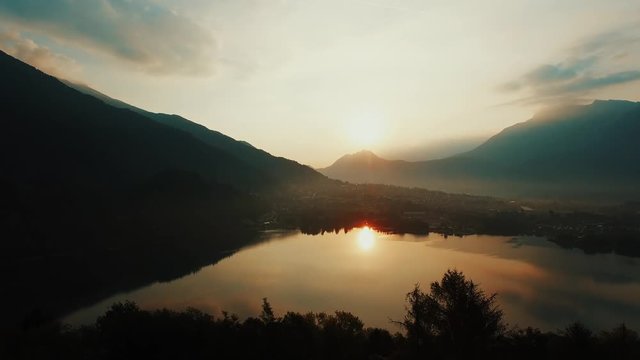 Lake sunset view. magic hour. golden dusk sky. aerial view. Levico, Italy.