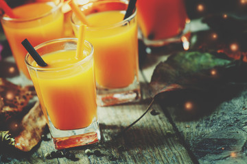Orange Halloween cocktail and holiday pumpkins on a dark mystical autumn background, selective...