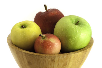 Pink, red, green and yellow apples in wooden bowl, isolated on white background