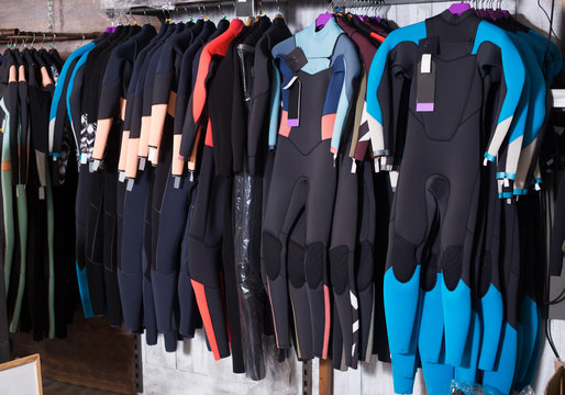 Image of colorful wetsuit hanging in the  store for surfing