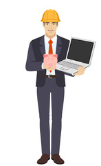Businessman in construction helmet holding a piggy bank and laptop notebook