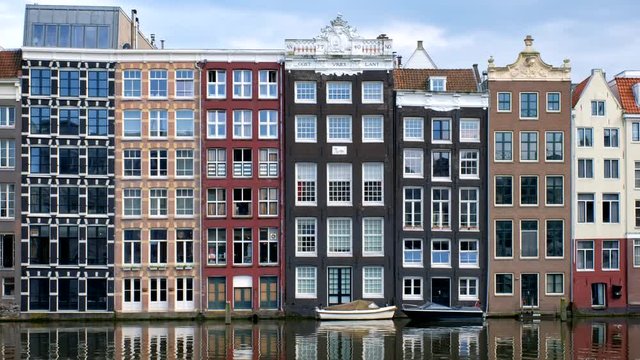 houses and boat on Amsterdam canal Damrak with reflection. Ams