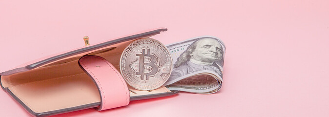 Bitcoin and dollars in a pink wallet on the pink background with copy space