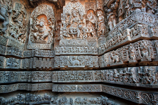 Shiva, Ganesh and many other sculptures on carved wall of 12th century historical Hoysaleswara Hindu temple, Halebidu, India.