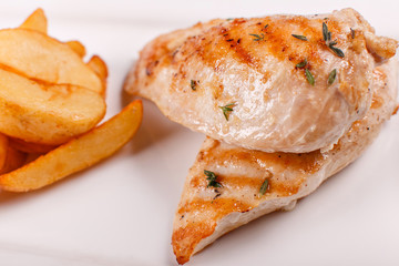 Hot and spicy hot meat dishes. Grilled chicken breast with french fries slices of rustic