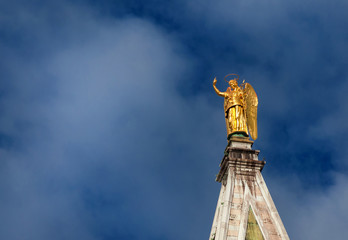 Golden angel statue among clouds, at the top of Saint Mark Bell Tower in Venice, erected in 1820...