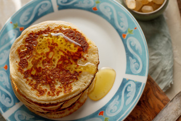 Tea, pancakes, honey, cream sauce and lavender on light concrete table, romantic breakfast pancake party, various morning food, healthy lifestyle. Selective focus, top view