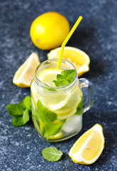 Mason jar glass of lemonade with mint on blue stone background