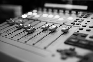 Sound recording studio mixing desk. Music mixer control panel. Closeup. Selective focus. Black and...