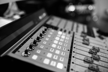 Sound recording studio mixing desk. Music mixer control panel. Closeup. Selective focus. Black and...