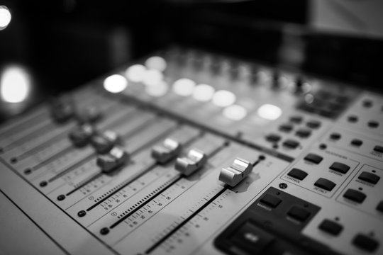 Sound recording studio mixing desk. Music mixer control panel. Closeup. Selective focus. Black and White image