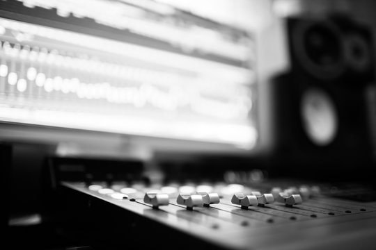 Sound recording studio mixing desk. Music mixer control panel. Closeup. Selective focus. Black and White image