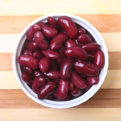 Heap of canned red kidney beans in the sauce in white bowl. vegetarian food. Phaseolus vulgaris.