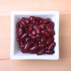 Heap of canned red kidney beans in the sauce in white bowl. vegetarian food. Phaseolus vulgaris.