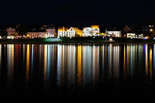 Troickoe predmeste is a picturesque old quarter on the bank of the Svisloch River in the center of Minsk. The night city is reflected in the river.