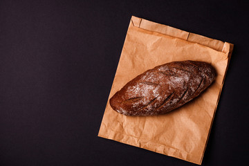 Fresh dark bread on dark background. Text place
