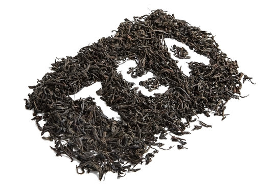 Dry black tea leaves. Isolated on white background. Inscription, word tea