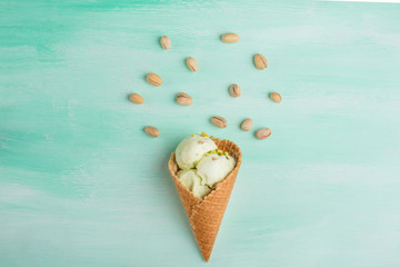 Pistachio ice cream balls in a waffle cone on a light background. View from above