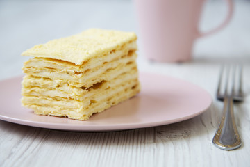Piece of Napoleon Cake on pink plate, closeup.