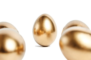 Golden eggs isolated on white background. Selective focus. Conceptual image