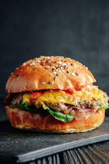 homemade  juicy burger on dark wooden board. Street food, fast food.