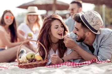 Beautiful young couple lying and having fun on the beach