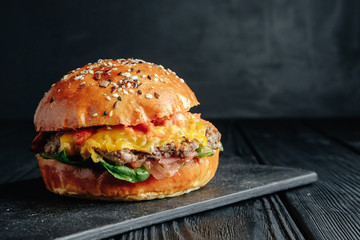 homemade  juicy burger on dark wooden board. Street food, fast food.