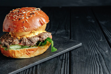 homemade  juicy burger on dark wooden board. Street food, fast food.