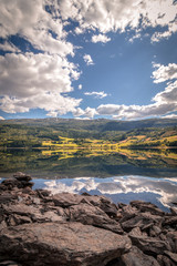 Norwegian mountain lake summer landscape. Clouds reflecting in the crystal clear water surface.