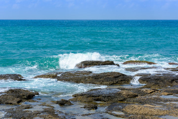 Fototapeta na wymiar view of the sea horizon and the waves with foam breaking on the coastal rocks