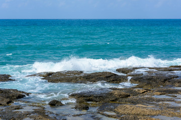 view of the Mediterranean horizon and the waves with foam breaking on the coastal stones