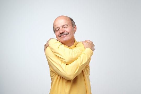 Closeup portrait confident smiling man hugging himself. I am the best concept.
