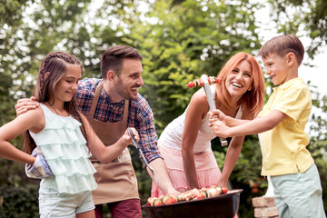 Young family having barbecue party in garden