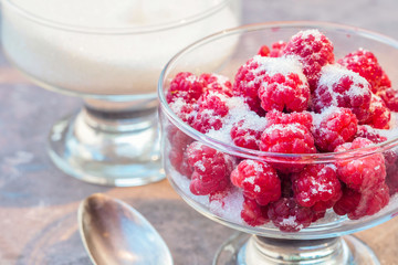 Glass of fresh raspberries sprinkled with white sugar gardening gastronomy harvest