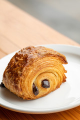 Close up on a flaky chocolate croissant