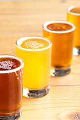 Diagonal row of taster beer glasses with rainbow color variety