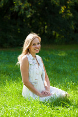 Young beautiful blonde woman in white dress