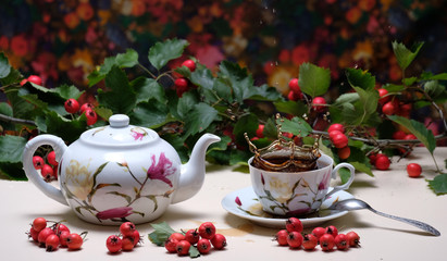 Still life with a kettle, a cup of tea and hawthorn. Food and health. Frozen tea.