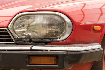 Vintage car headlight. Retro headlamp with wiper on classic vehicle.