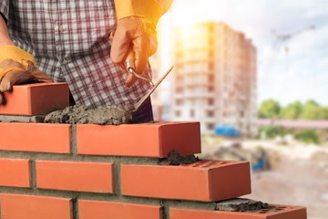 Worker builds a brick wall