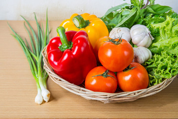 Organic vegetables in the wicker basket on wooden background