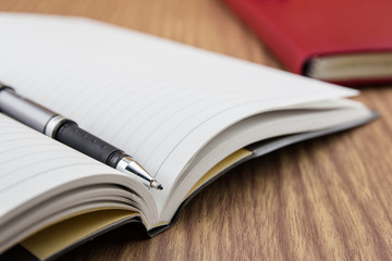 book with pen, mobile and keyborad on desk